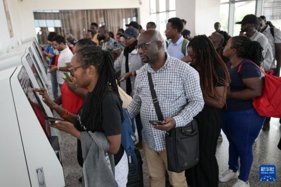 5月31日，在蒙內(nèi)鐵路內(nèi)羅畢站，乘客在自助取票機(jī)前排隊取票。新華社記者 楊光 攝