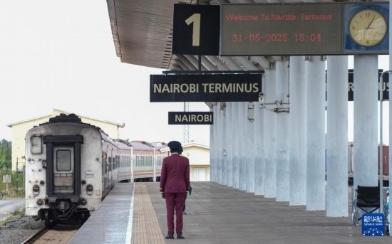 5月31日，在蒙內(nèi)鐵路內(nèi)羅畢站，工作人員目送開往蒙巴薩的E2次列車駛離站臺。新華社記者 李亞輝 攝